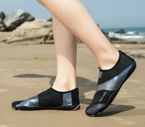 Homme avec chaussures de plage Motion Argent d'Aquashoes marchant sur le sable